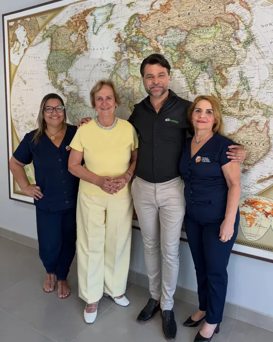 Equipe da Pedra Grande em pé dentro da loja, na frente de um mapa-múndi emoldurado.